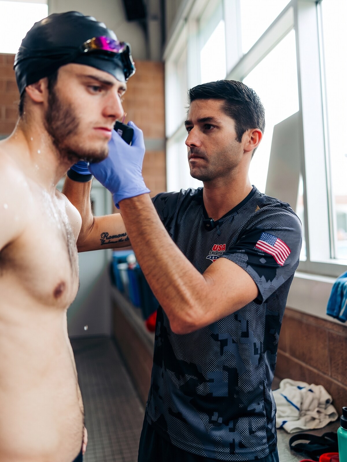 USA Triathlon coach taking an earlobe lactate sample from an athlete during field testing