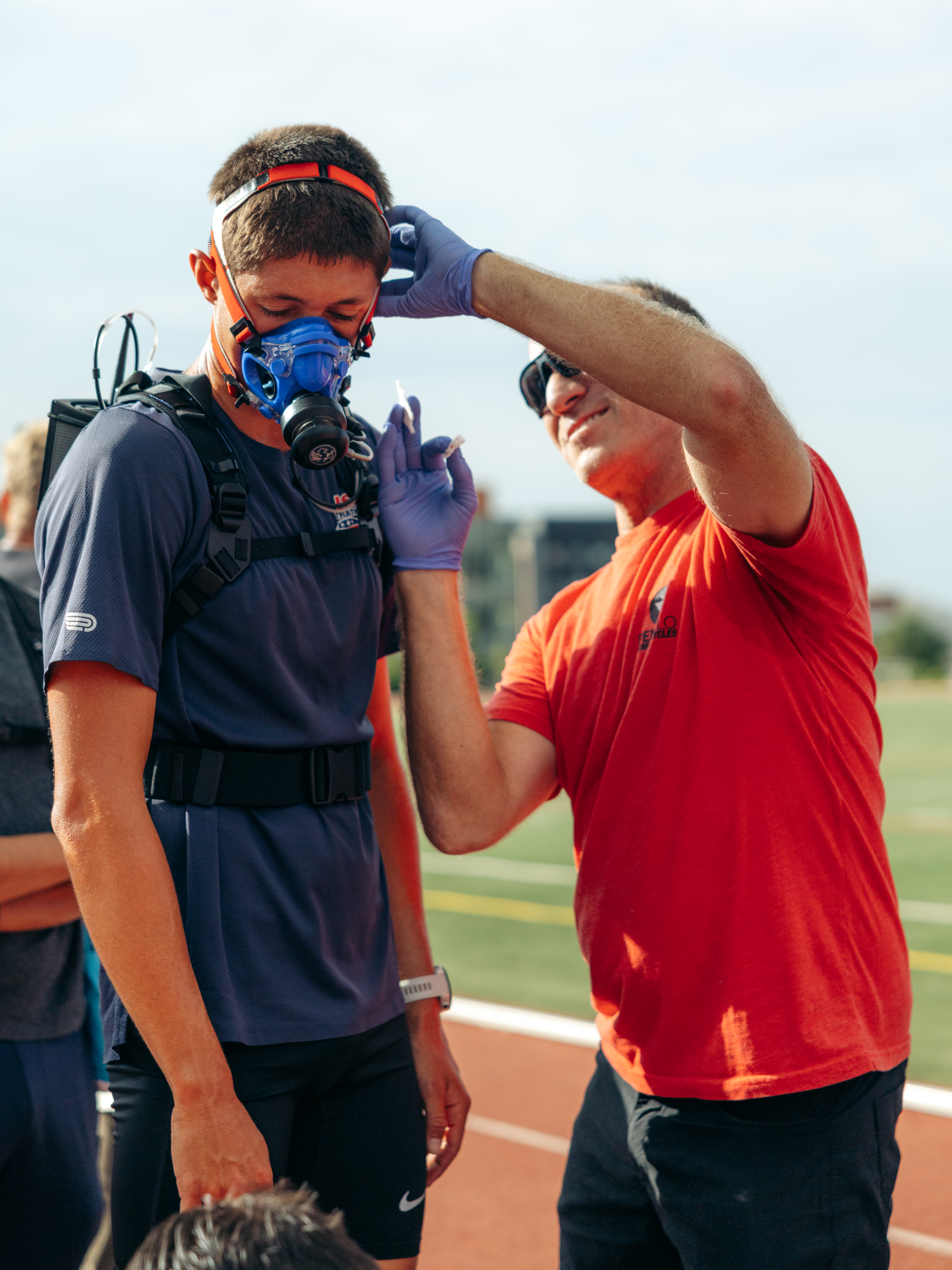 Coach fitting a VO2 mask on an athlete at the camp