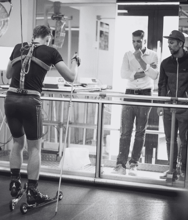 Coach fitting a VO2 testing mask on an athlete outdoors