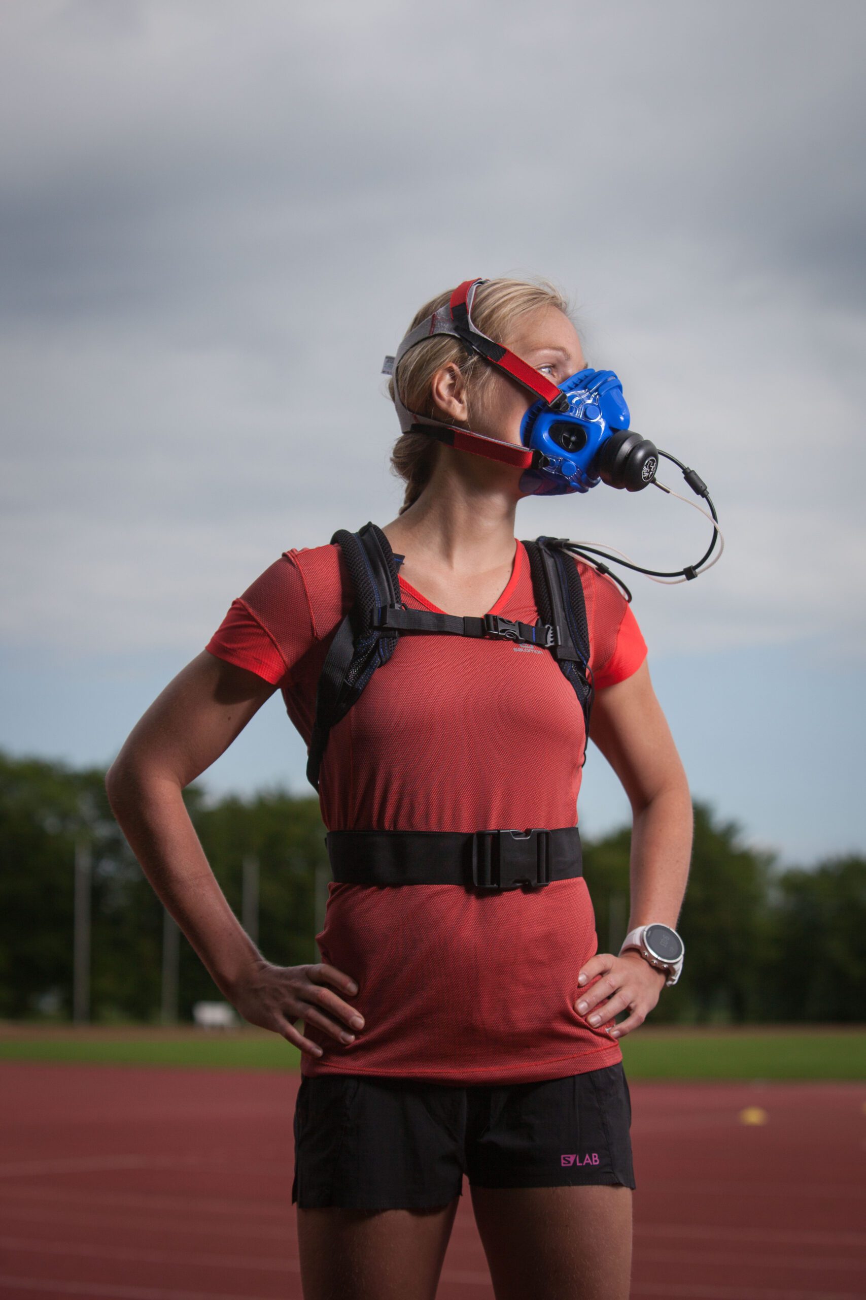 Runner on a track wearing a portable VO2 testing mask