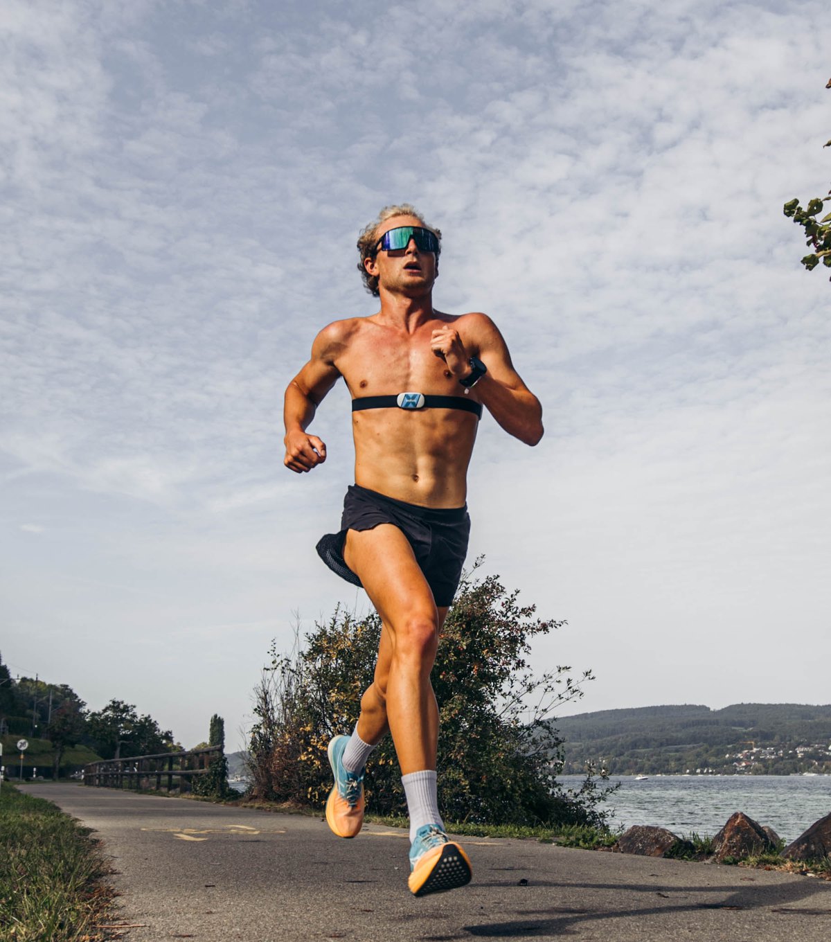 A runner sprinting along a lakeside path, a maximal effort of the kind the sprint test uses
