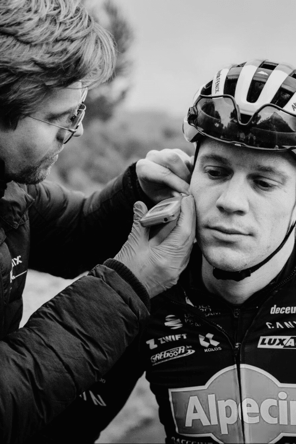 Coach fitting a sensor on a cyclist before a performance test